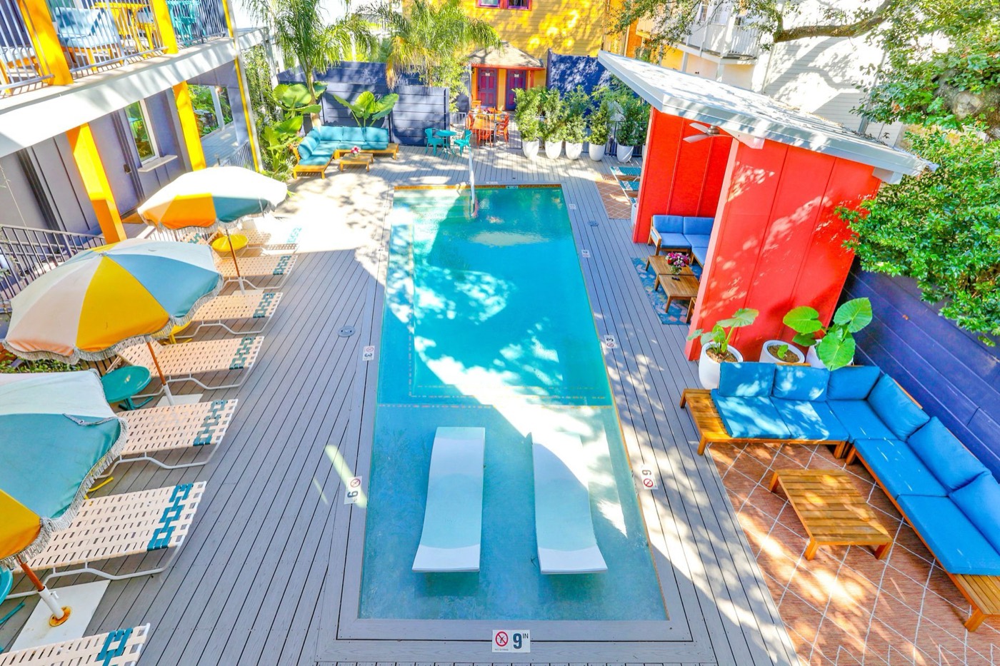 Colorful courtyard pool with umbrellas and loungers in New Orleans